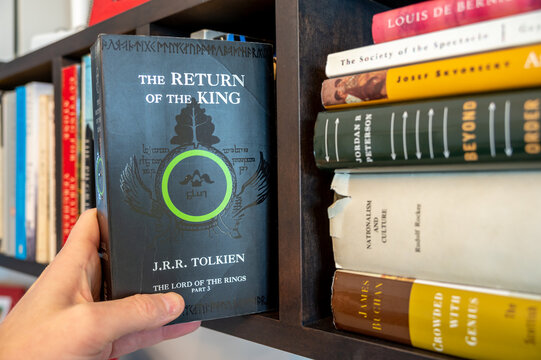 Calgary, Alberta - December 22, 2022: Pulling JRR Tolkien's The TReturn of the King of a bookshelf.