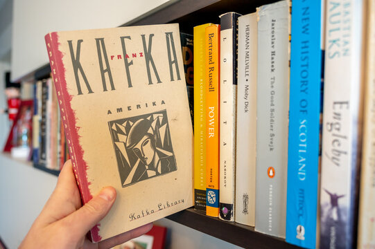 Calgary, Alberta - December 22, 2022: Pulling Kafka's  Amerika of a bookshelf.