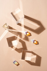 Glass prisms reflect light making beautiful shadows on beige background