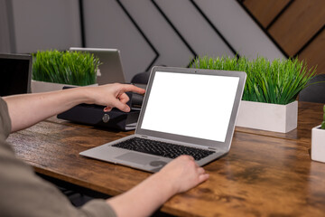 Finger hand showing, pointing at laptop screen mockup. Computer display mock up in modern office