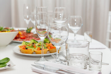 Served for holiday banquet restaurant table with dishes, snack, cutlery, wine and water glasses.