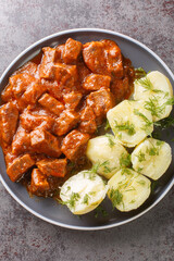 Authentic Austrian beef goulash which is known for its especially thick gravy closeup on the plate on the table. Vertical top view from above