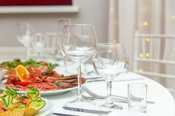 Served for holiday banquet restaurant table with dishes, snack, cutlery, wine and water glasses.