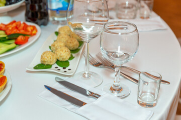 Served for holiday banquet restaurant table with dishes, snack, cutlery, wine and water glasses.