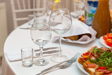 Served for holiday banquet restaurant table with dishes, snack, cutlery, wine and water glasses.