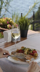 Salmon and white wine in restaurant with sea view