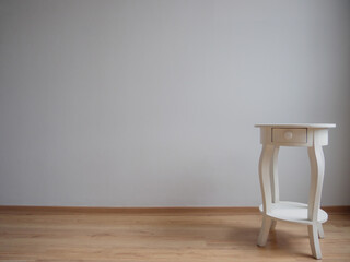 Mesa de madera blanca aislada en un fondo gris claro con piso de madera, aislado, minimalista