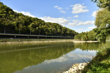 Obraz premium La Meuse avec voie de circulation routière entre les hautes collines boisées à Lustin au sud de Namur
