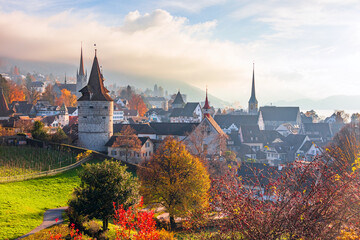 Fototapeta na wymiar A breathtaking panoramic view of the buildings and fortifications of the old town of Zug in autumn, the Guggi Vantage Point in Zug