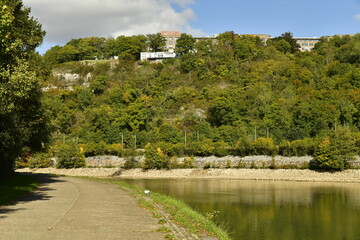 Fototapeta premium Petite route secondaire pour la promenade longeant la Meuse entre Yvoir ,Godinne et Lustin au milieu d'un paysage bucolique de collines boisées à une dizaine de Km au sud de Namur 