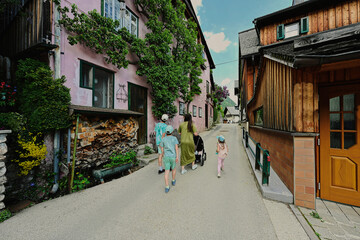 Mother with baby carriage and children walking in Hallstatt, Austria.