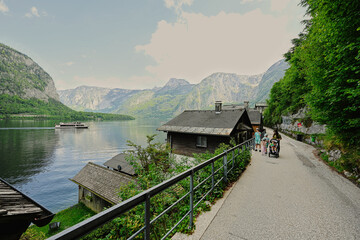 Fototapeta premium Mother with baby carriage and children walking in Hallstatt, Austria.