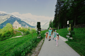 Family walking near mirror cube at path to caves Mount Krippenstein in Hallstatt, Upper Austria, Europe.