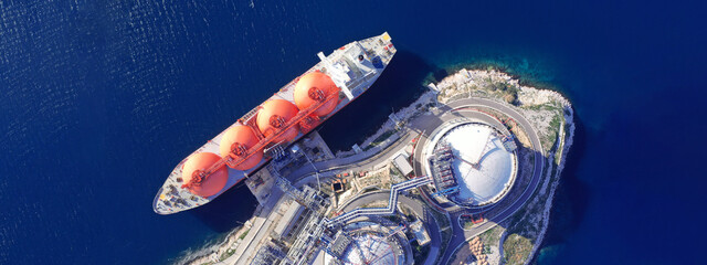Aerial drone ultra wide photo of LNG (Liquified Natural Gas) tanker anchored in small LNG...