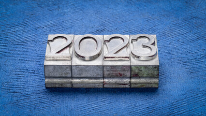 2023 year in grunge metal type against blue textured paper, New Year concept