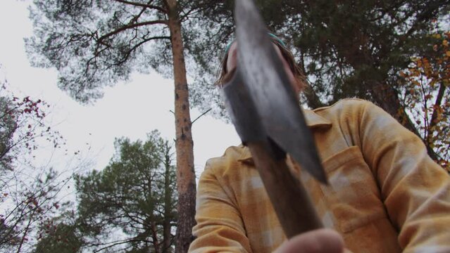 Bearded man swings an axe - bottom-up view