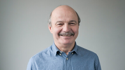 Portrait of smiling mature man standing on white background.