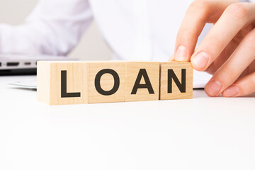hand holding wooden cube with LOAN text on table background. financial, marketing and business concepts