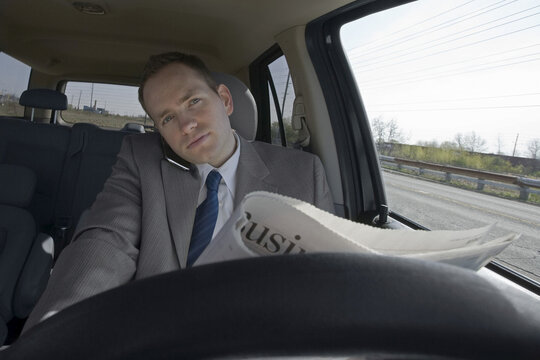 Driver Talking on Cell Phone and Reading Newspaper