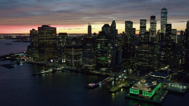 
Aerial View of the Financial District in Lower Manhattan at Sunset. Famous Skyscrapers and Traffic over FDR dr. East River.  High Quality Footage Shot from Helicopter. New York City, United States.