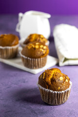 Vanilla Caramel Nuts Muffins In Paper Cups On purple background 