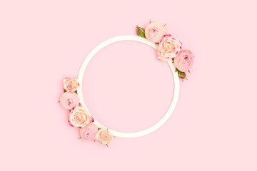 Round frame made of rose flowers on a pink background. Cute festive floral concept.