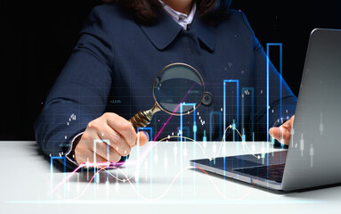 Woman sits at a laptop in front of a holographic chart with growing indicators. Business...
