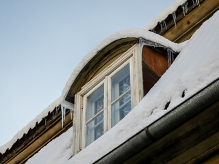 Roof window and tiles in snowy winter day, Kuldiga, Latvia.