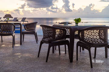table et chaises bistro avec vue sur la mer lors d'un matin avec des nuages dans le ciel