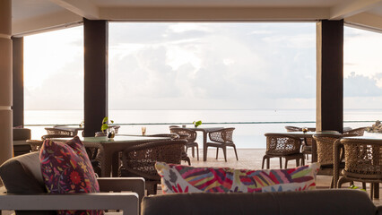 table et chaises bistro avec vue sur la mer lors d'un matin ennuagé sous un toit