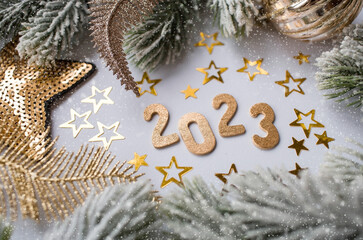 Happy New Year and Merry Christmas. Golden numbers 2023, snow, fir branches, Christmas tree toys and golden stars on a white background. Banner. invitation.