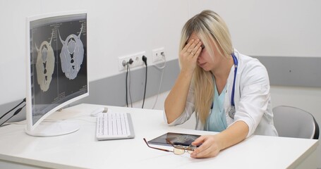 Veterinarian woman in depression sits at the table. The doctor is exhausted and desperately trying...