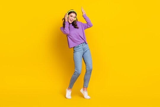 Full body photo of overjoyed cheerful lady hand touch headphones enjoy favorite single isolated on yellow color background