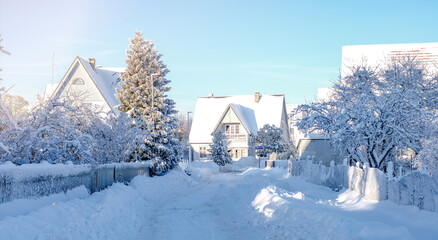 Winter fairy-tale landscape on the street with houses with a triangular roof and roads covered with a lot of snow
