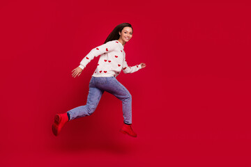 Full length photo of pretty cute girl dressed white pullover jumping high running fast empty space isolated red color background