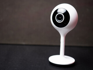 Picture of a white table top IP CCTV camera with modern design on a black background
