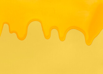 Pouring honey on a yellow background.