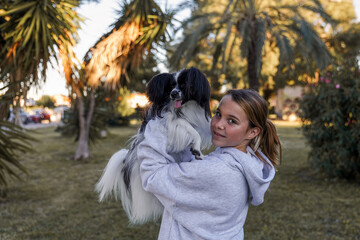 A girl plays with a dog in the park