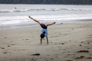 Young girl doing gymnastics on long beach