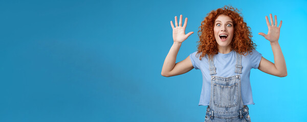 Excited crazy playful funny redhead curly emotive girl yelling carefree raise hands surrender up...