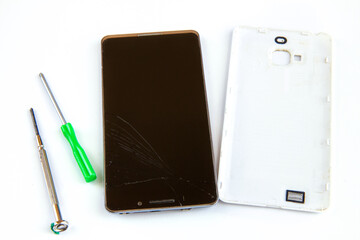 Smartfon z uszkodzonym ekranem i śrubokręty na białym tle. Motyw naprawy smartfona - obrazy, fototapety, plakaty