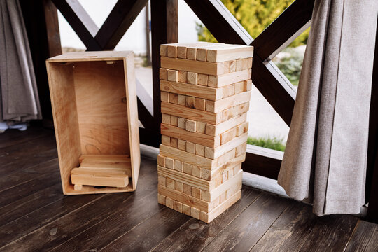 Jenga, multistory tower of wooden blocks. Group game of physical skill with big blocks for outdoors, vertical. Game for children and adult persons