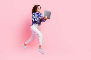 Full size photo of active energetic girl jump run use netbook empty space isolated on pink color background