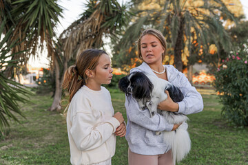 Girls playing with a dog in the park