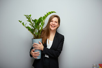 Laughing woman in black suit holding home plant. Isolated female portrait. - 555770195