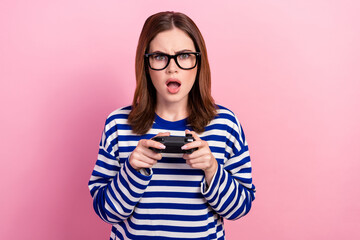 Fototapeta premium Photo of astonished impressed worried outraged lady hold playstation game over isolated on pink color background