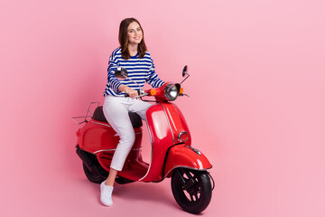 Full size photo of charming cheerful girl sit drive moped enjoy weekend isolated on pink color...
