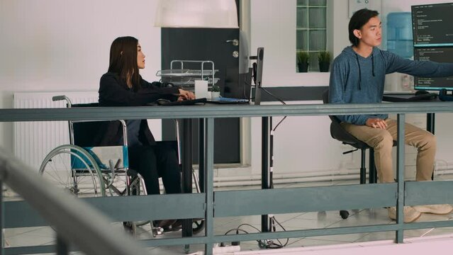 Database programer with physical disability writing code on computer screen, coding artificial intelligence algorithm. Engineer with impairment programming database on terminal window.