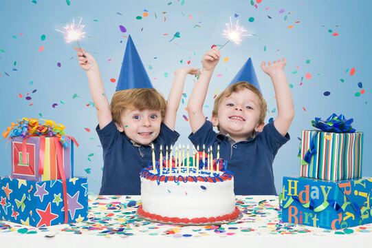 Twin Boys holding Sparklers with Birthday Cake and Presents