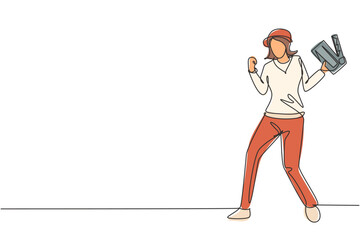 Single one line drawing female film director stands with celebrate gesture holding clapperboard and prepare camera crew for shooting at studio. Continuous line draw design graphic vector illustration